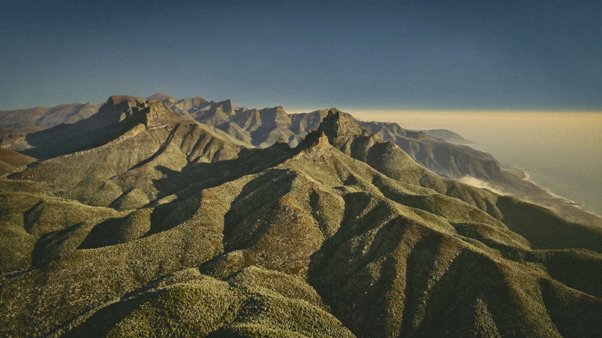 Steep fynbos-covered slopes running down toward the coast near Cape Town