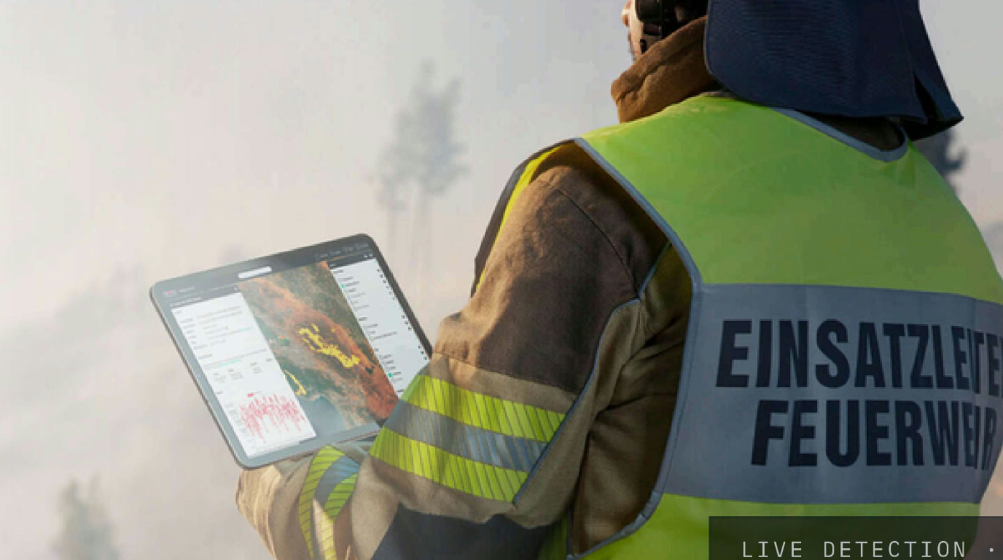 An incident commander reading live fire detections on a tablet at the fire line
